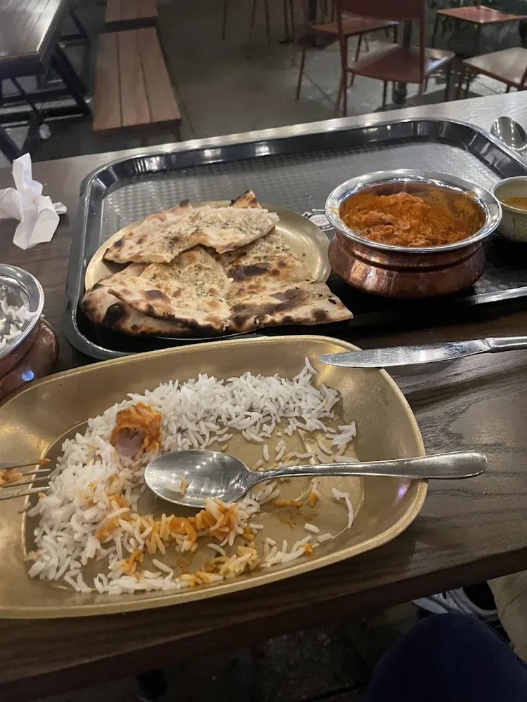 A dine-in tray of rice, naan and curry at Little High Eatery