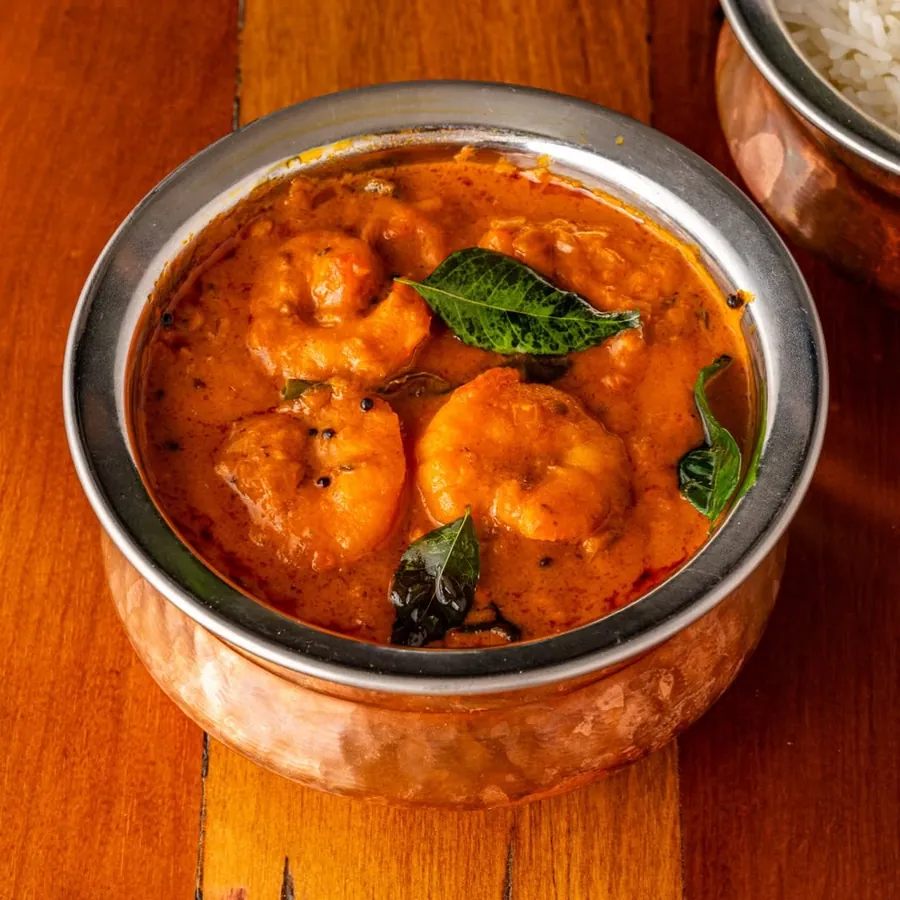 Prawn curry with curry leaves in a copper bowl