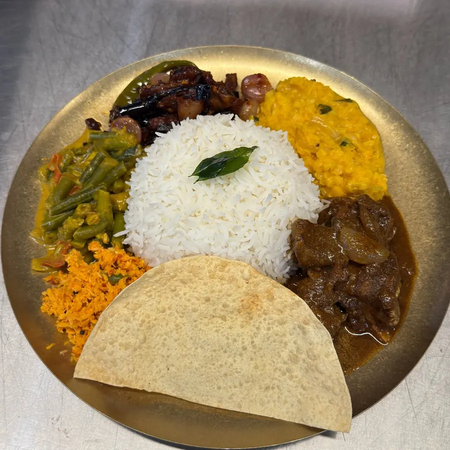 Sri Lankan rice and curry plate with dhal, beans, sambol and pappadam